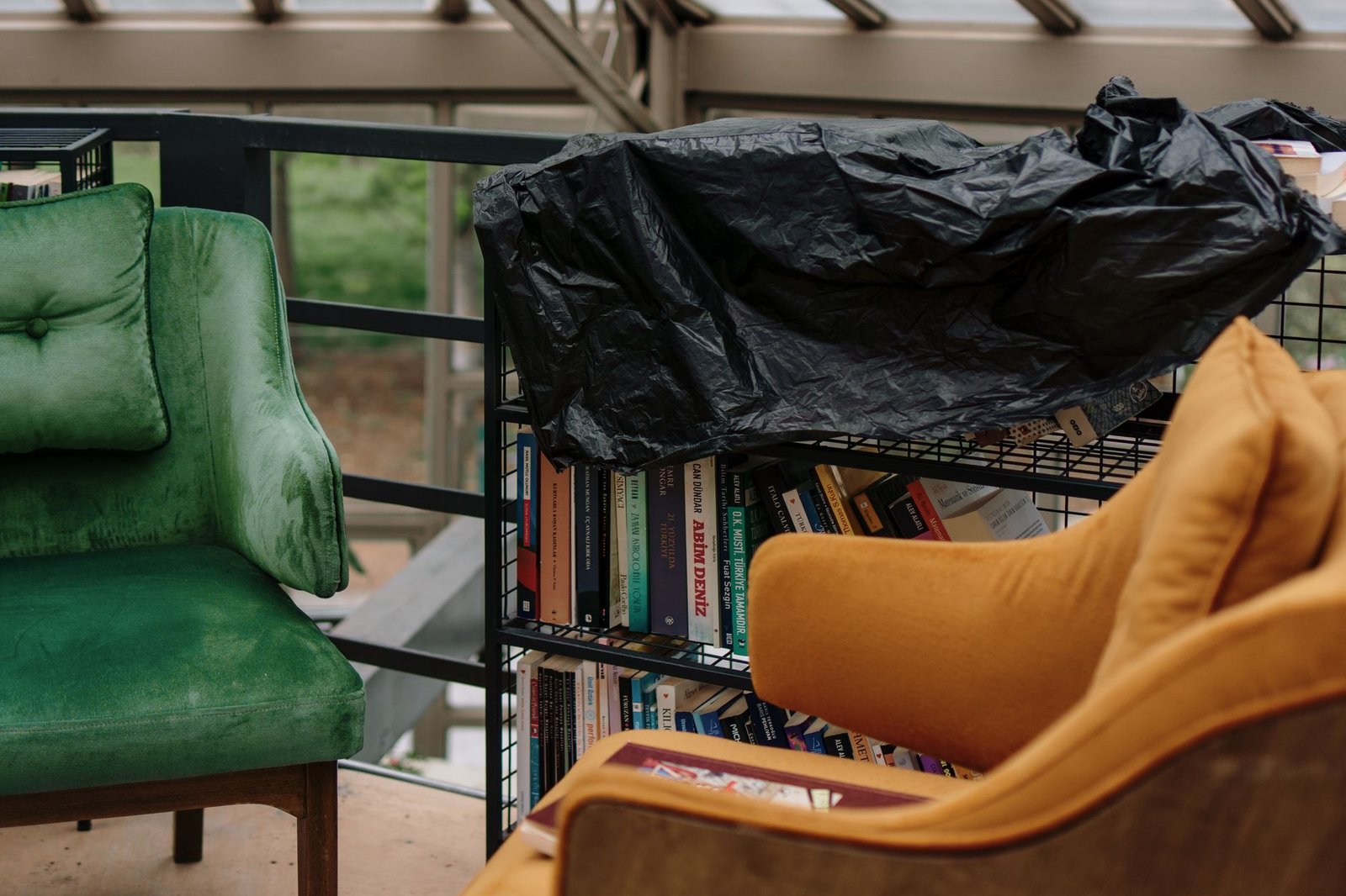 Warm and inviting reading nook with soft cushions, ambient lighting, and a stack of books by a window