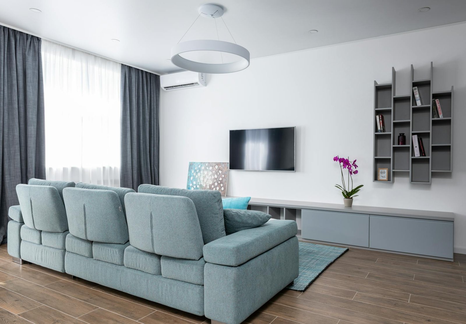 Bright and tidy living space with organised shelves and natural wicker storage baskets in neutral tones