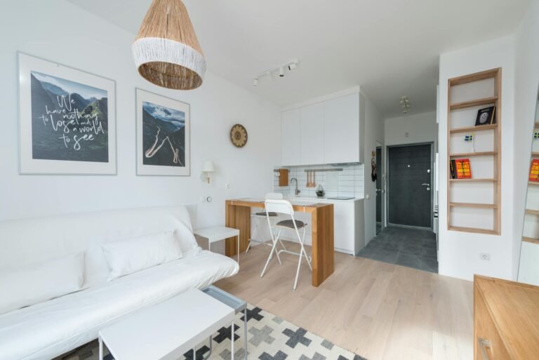 Neatly organised small apartment living space with clever storage baskets and shelving units in warm neutral tones
