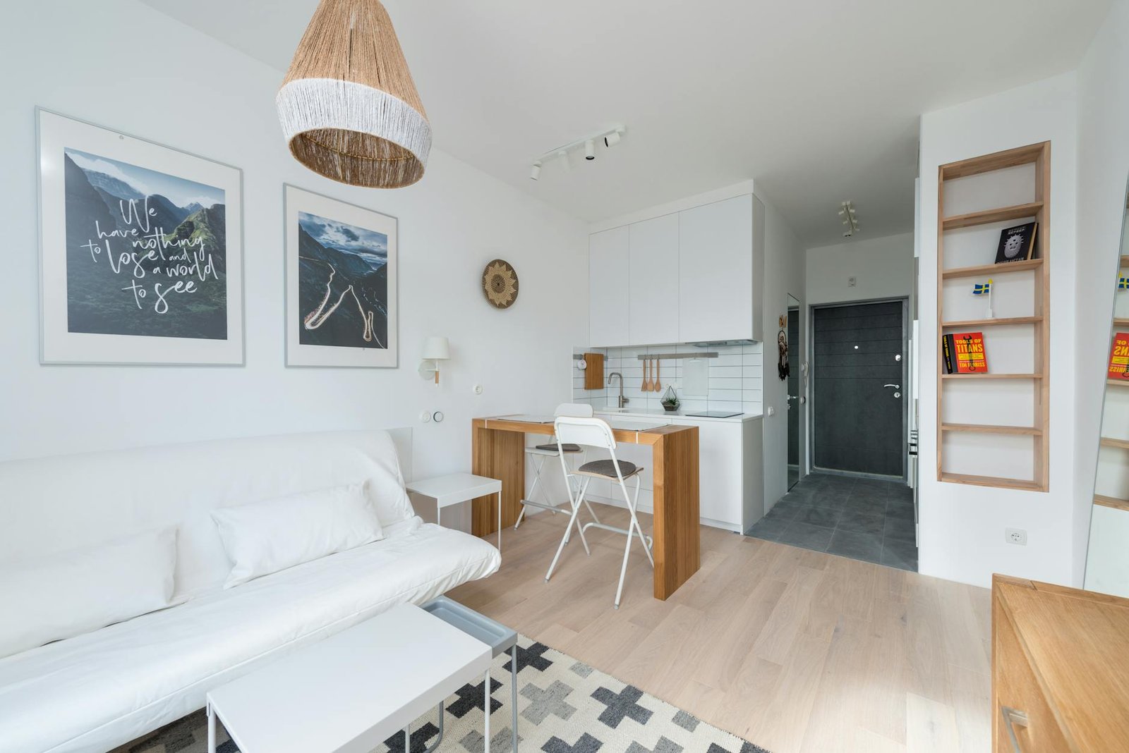 Neatly organised small apartment living space with clever storage baskets and shelving units in warm neutral tones