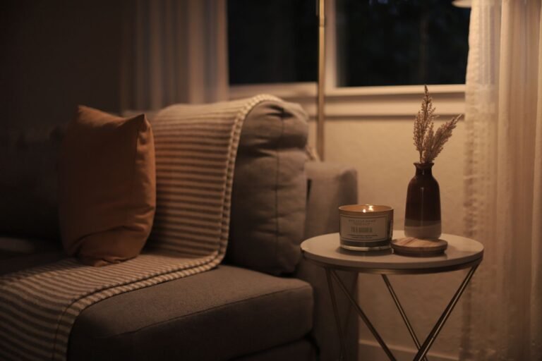 Warm scented candles glowing softly on a living room coffee table creating cozy ambiance