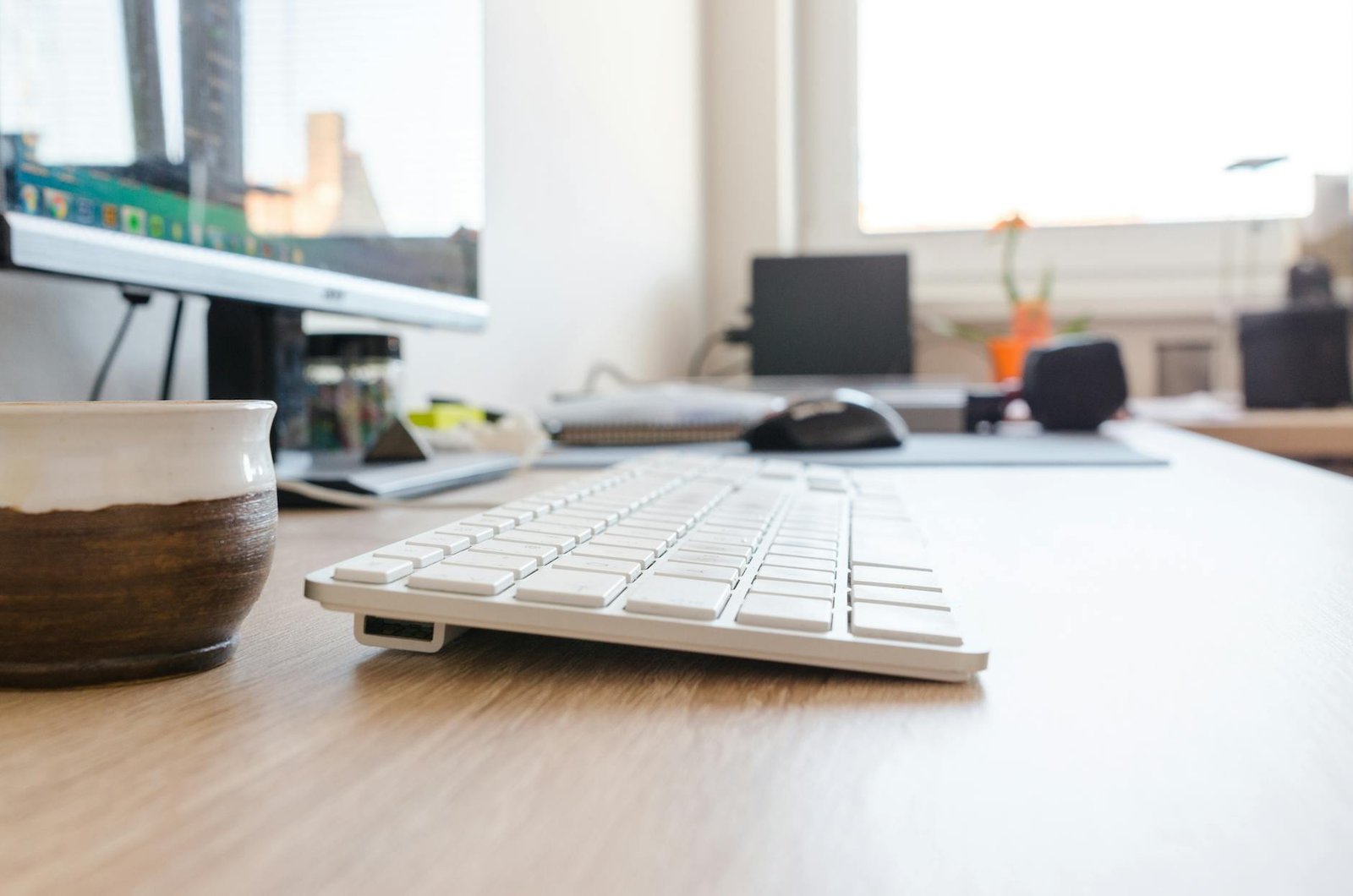 Clean minimalist home office desk with neatly organised cables and warm natural lighting