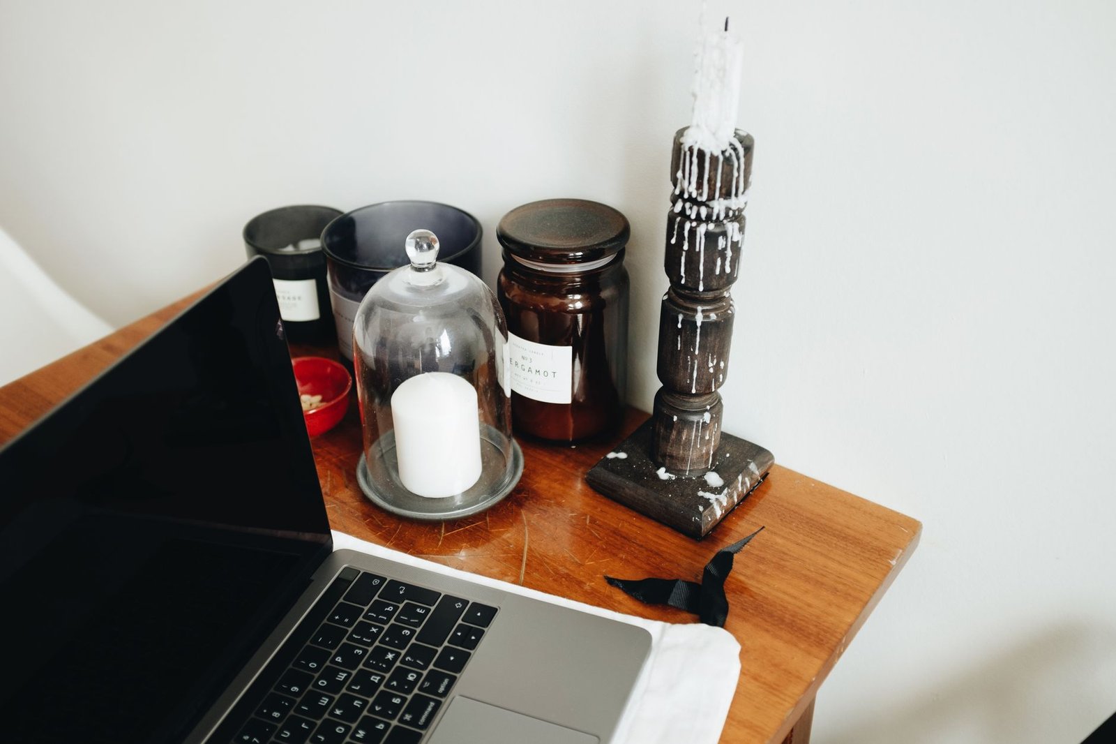 Warm minimalist home office with wooden desk, soft lamp lighting, and plants near a sunny window