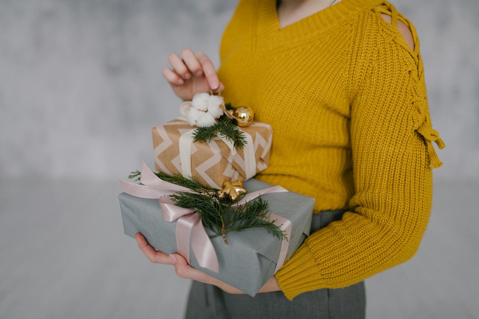 Beautifully wrapped home gifts including candles and soft throws arranged on a cozy living room setting