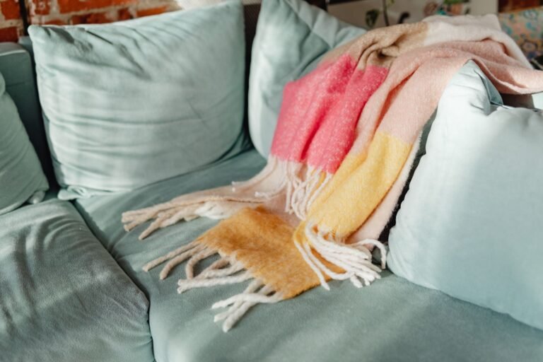 Warm living room with layered textiles, soft lighting, and a chunky knit throw draped over a linen sofa