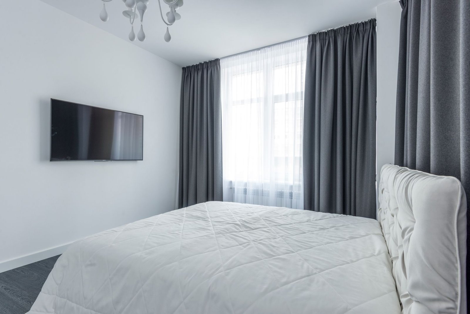 Soft blackout curtains framing a bedroom window with warm morning light filtering through the edges