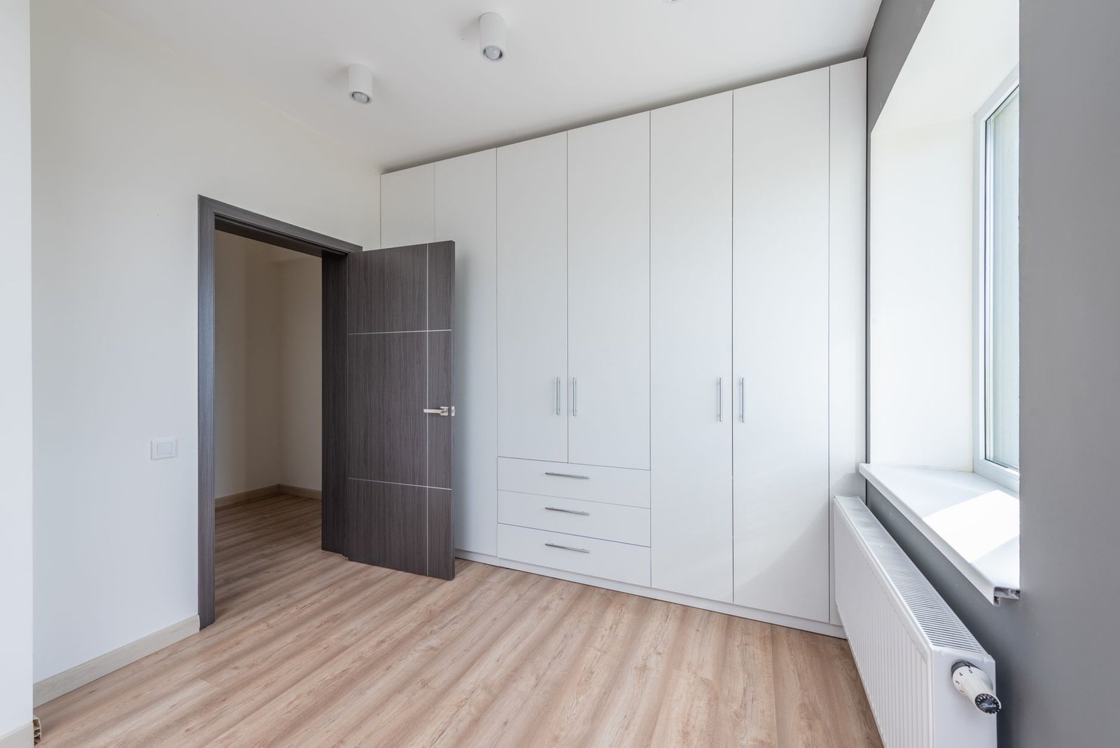 Over door organiser with clear pockets hanging on white bedroom door holding accessories and small items