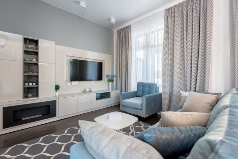 Neutral woven area rug anchoring a cozy living room seating arrangement with sofa and armchairs